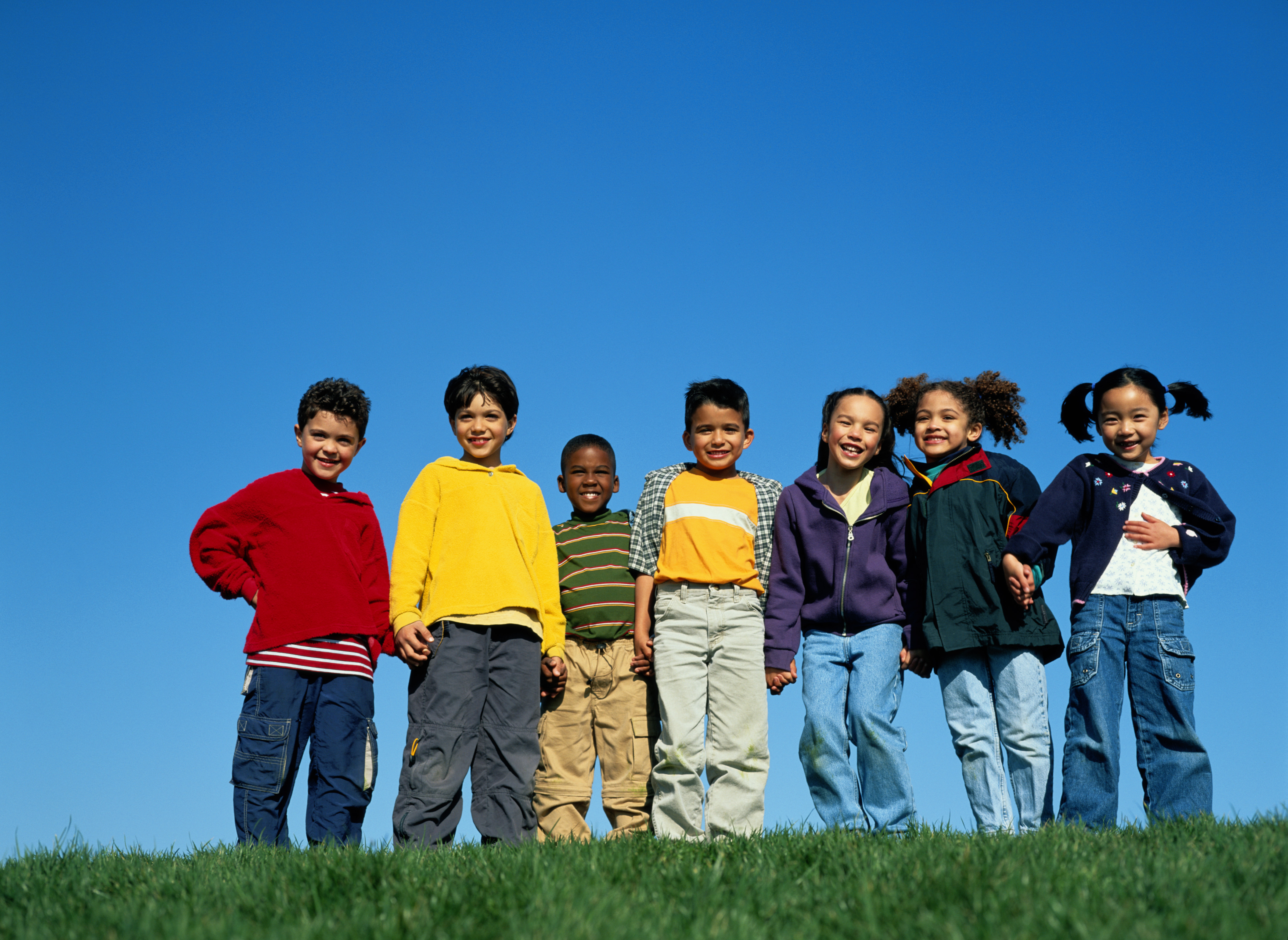 7 young refugee boys and girls stading on a hilltop