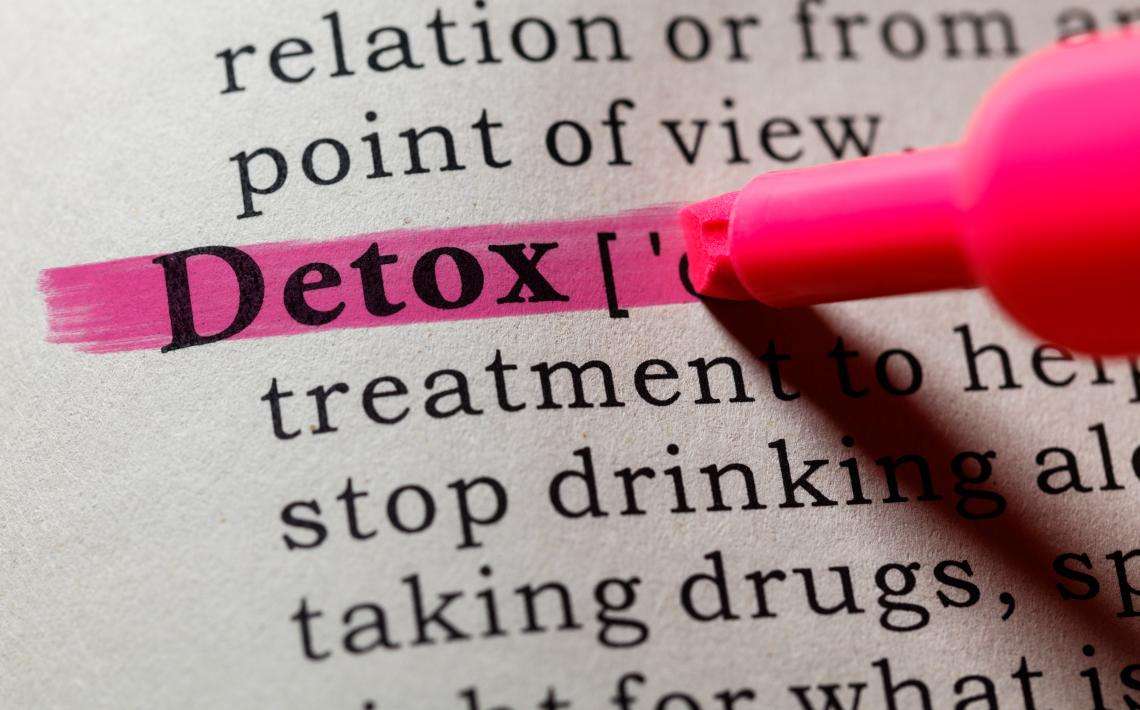 Detox on a page of print highlighted with pink marker