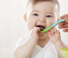 Smiling Baby eating baby food 