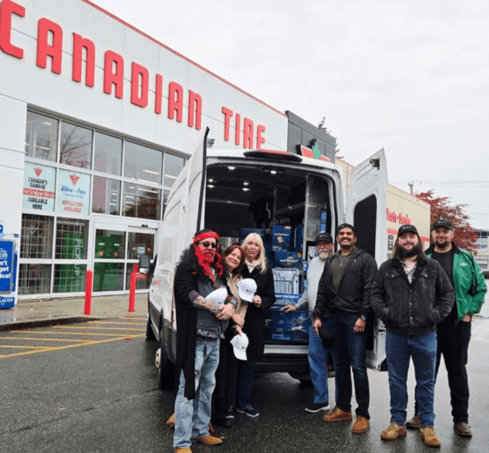 Carmen Hall (middle), Director of Homelessness and Housing and Ginny Hasselfield (middle), Director of Development Options Community Services, receiving tools and equipment from the Canadian Tire (Newton Store)
