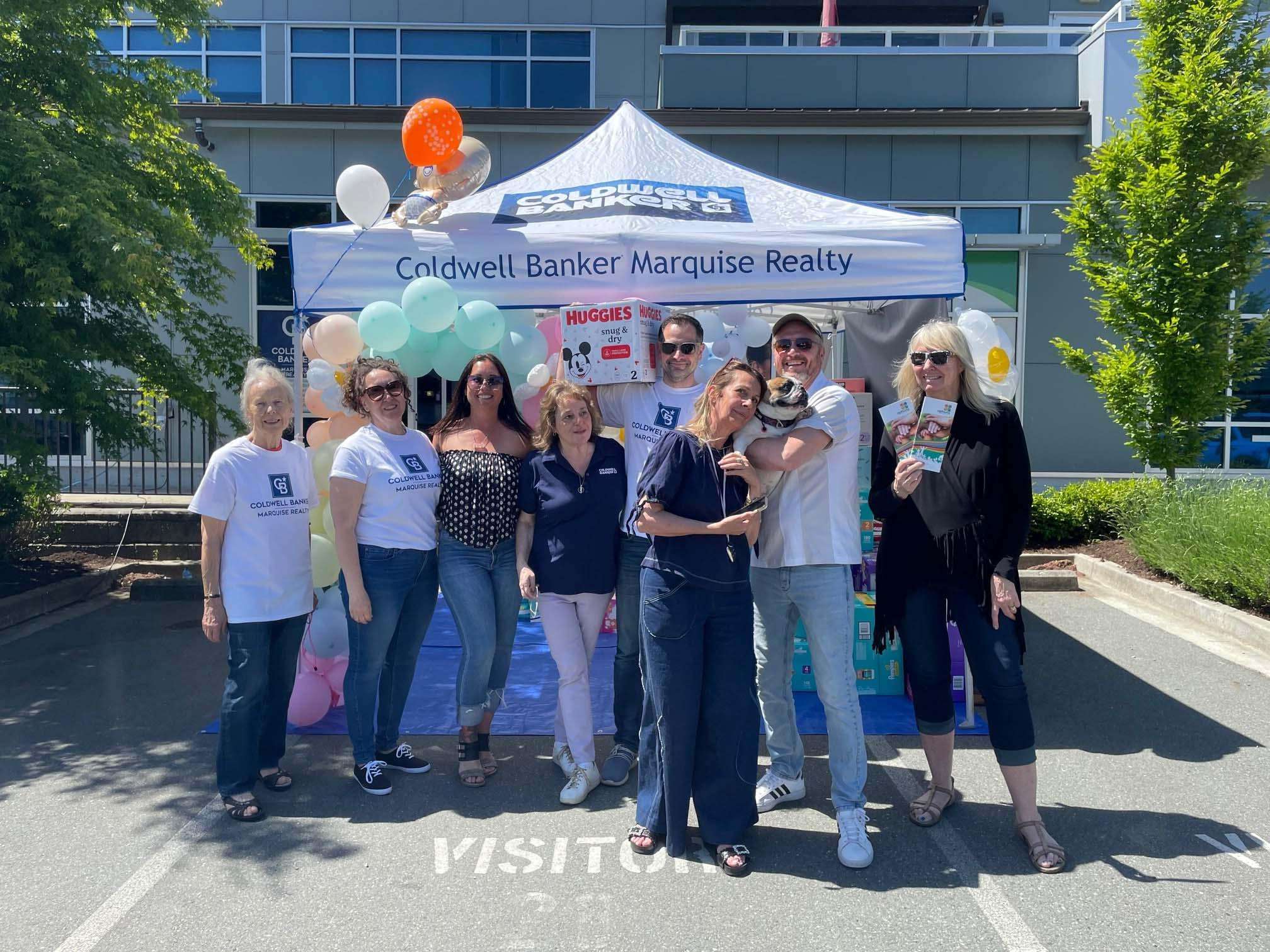 People standing in front of table of diaper donations.