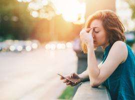 A young girl seems to have read some bad news on her phone